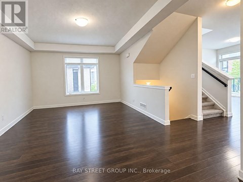 A spacious room with wooden floors and a window.