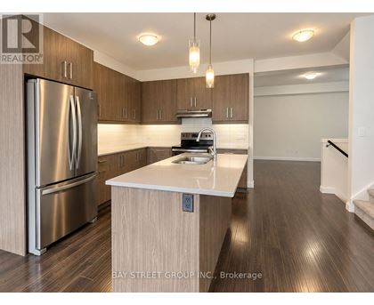 A modern kitchen with a stainless steel refrigerator and wooden cabinets.
