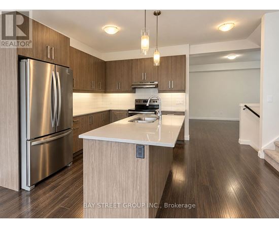 A modern kitchen with a stainless steel refrigerator and wooden cabinets.