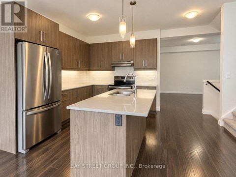 A modern kitchen with a stainless steel refrigerator and wooden cabinets.