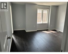 A room with a window and wooden flooring.