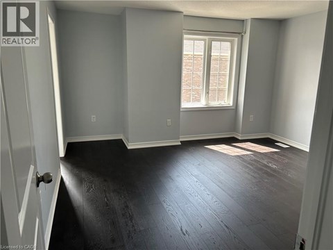 A room with a window and wooden flooring.