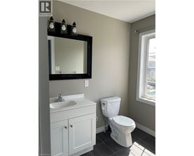 A white toilet sits next to a sink in a bathroom.