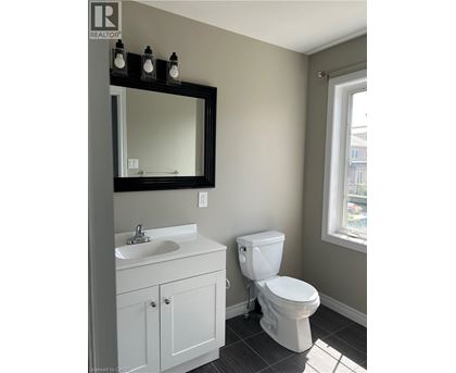 A white toilet sits next to a sink in a bathroom.