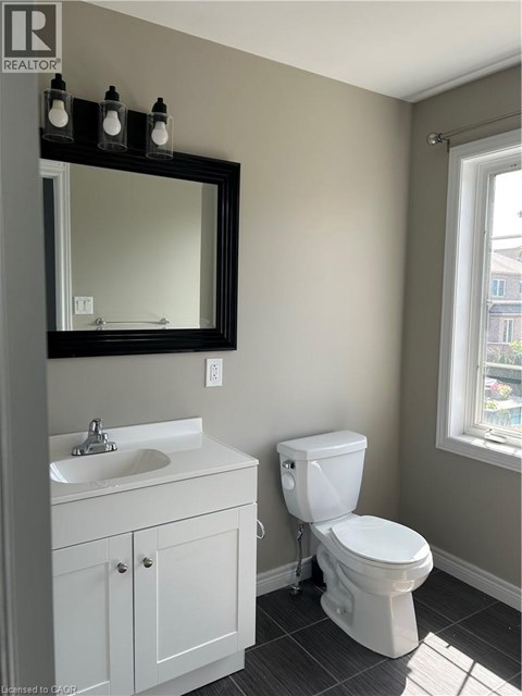 A white toilet sits next to a sink in a bathroom.