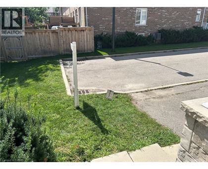 A sign that says REALTOR is on a post in the grass.