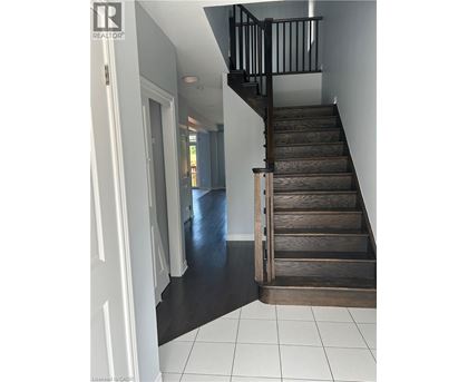 A wooden staircase with a black railing.
