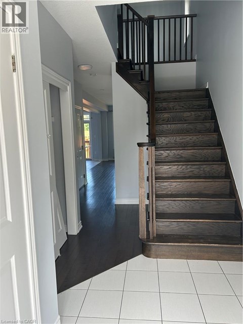 A wooden staircase with a black railing.