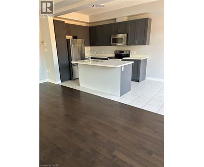 A kitchen with a white counter top and a refrigerator.