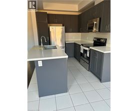 A kitchen with a white counter top and a stainless steel refrigerator.