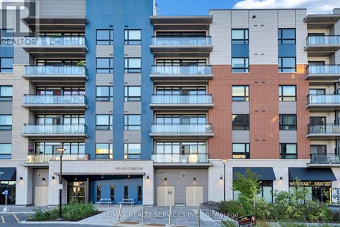 A multi-story apartment building with a Re/Max Realty Services Inc. sign in front.