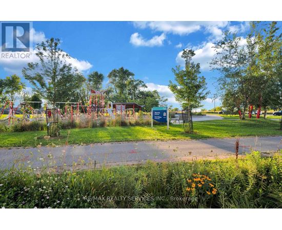 A playground with a blue sign in the foreground and trees in the background.