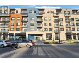A modern apartment building with cars parked in front.