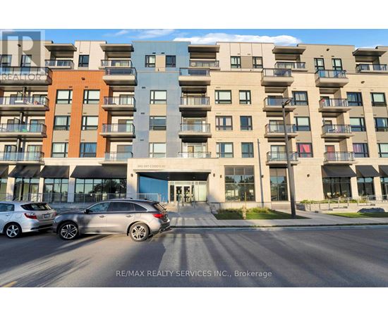 A modern apartment building with cars parked in front.