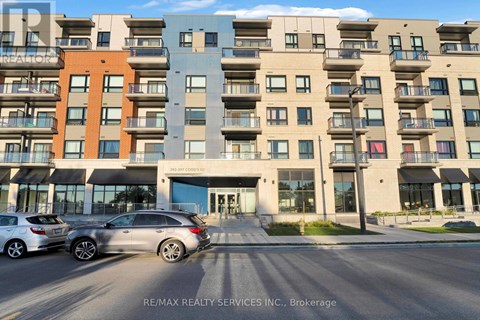 A modern apartment building with cars parked in front.