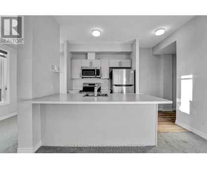 A modern kitchen with white cabinets and appliances.