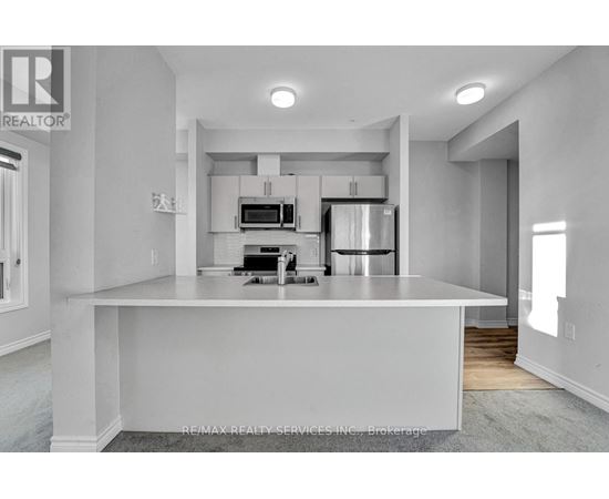 A modern kitchen with white cabinets and appliances.
