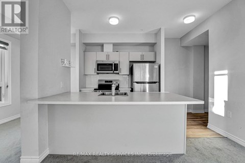 A modern kitchen with white cabinets and appliances.