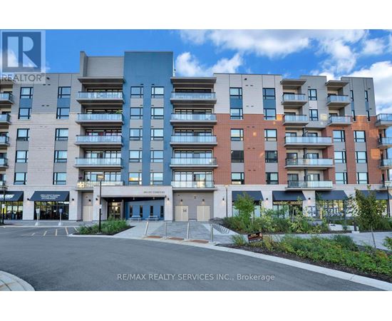A multi-story apartment building with a parking lot in front.