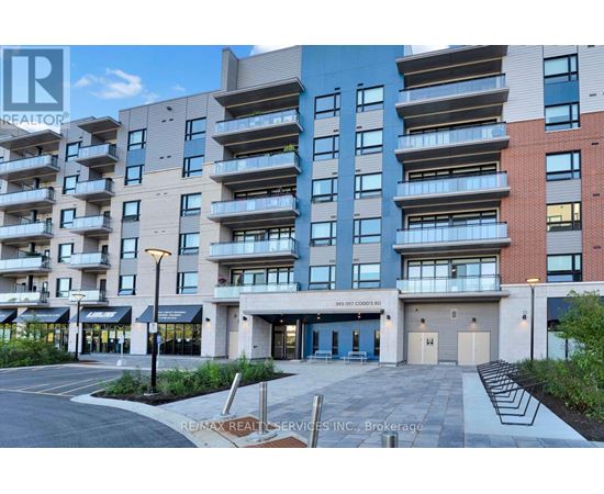 A modern apartment building with a parking lot in front.