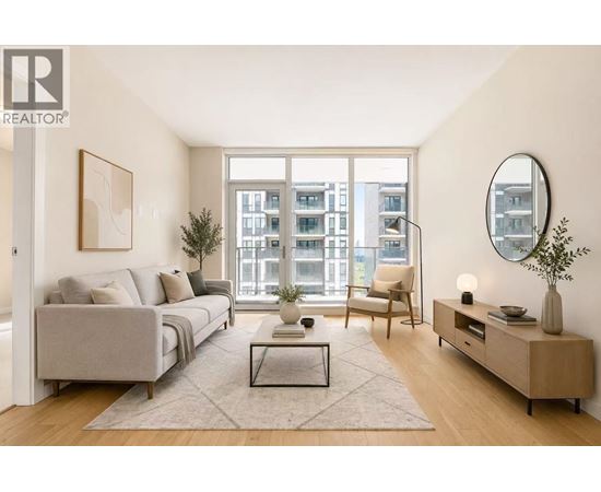 A living room with a grey couch, a coffee table, a chair, a side table, and a large window.