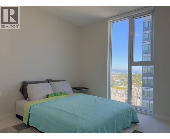 A bedroom with a large bed and a view of the city.