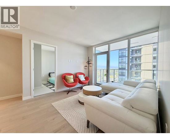 A living room with a white couch and a large window.