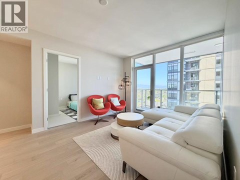 A living room with a white couch and a large window.