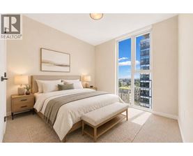 A bedroom with a large bed and a view of the city.
