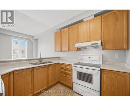 A kitchen with wooden cabinets and a white oven.