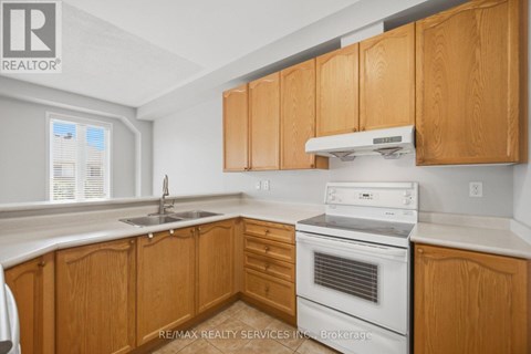 A kitchen with wooden cabinets and a white oven.