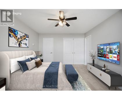 A bedroom with a large bed and a TV on the wall.