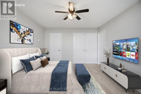 A bedroom with a large bed and a TV on the wall.