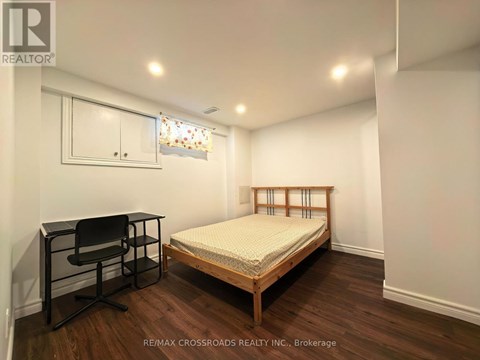 A bedroom with a bed, desk, and chair.