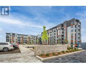 A modern apartment complex with a sign in front that reads "905 Dundas Street" and "50 Kaiting Trail".