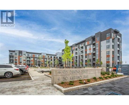 A modern apartment complex with a sign in front that reads "905 Dundas Street" and "50 Kaiting Trail".