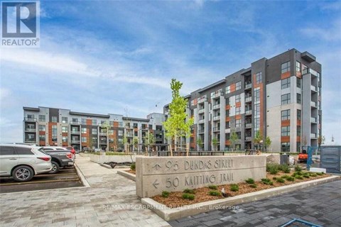 A modern apartment complex with a sign in front that reads "905 Dundas Street" and "50 Kaiting Trail".