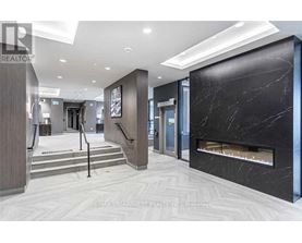 A hallway with a marble fireplace and a staircase.