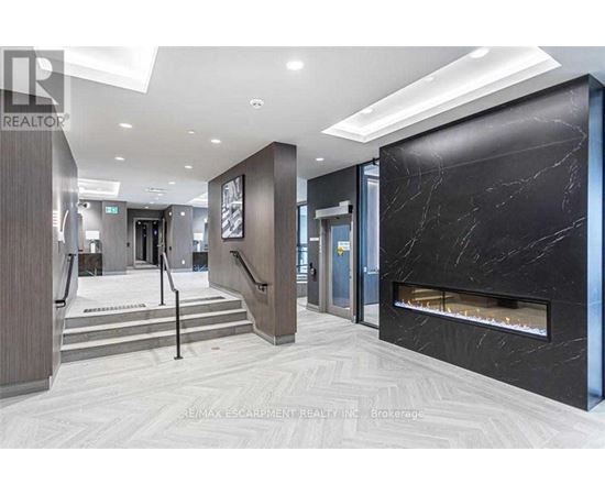 A hallway with a marble fireplace and a staircase.