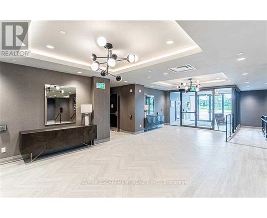 A spacious room with a wooden floor and a mirror on the wall.
