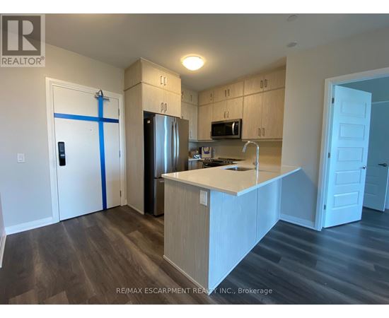 A kitchen with a white counter top and wooden cabinets.