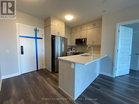 A kitchen with a white counter top and wooden cabinets.