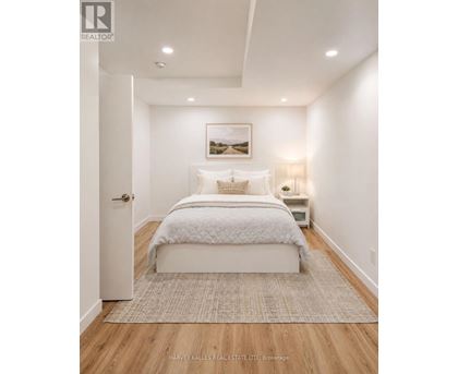 A bedroom with a large bed and a painting on the wall.