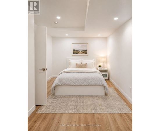 A bedroom with a large bed and a painting on the wall.