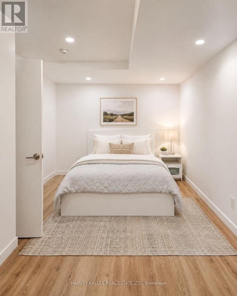 A bedroom with a large bed and a painting on the wall.