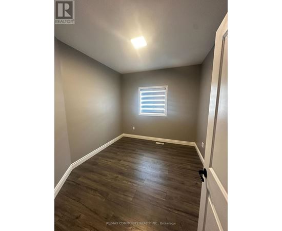 A room with a window and wooden flooring.
