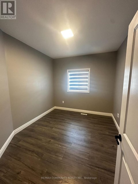 A room with a window and wooden flooring.