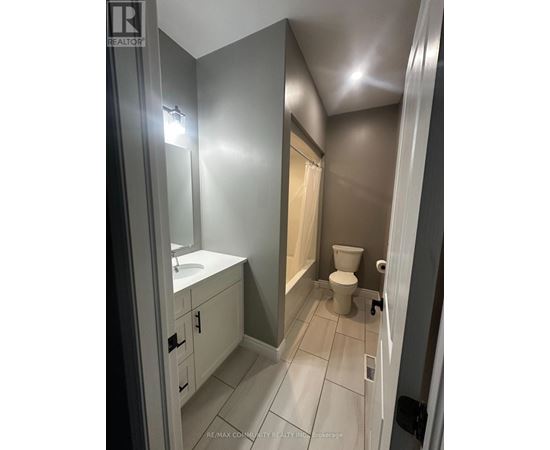A bathroom with a toilet, sink, and mirror.