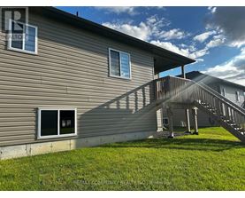 A house with a grey siding and a wooden deck.