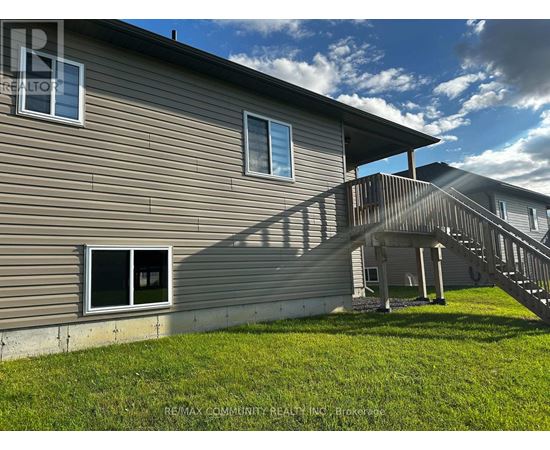 A house with a grey siding and a wooden deck.